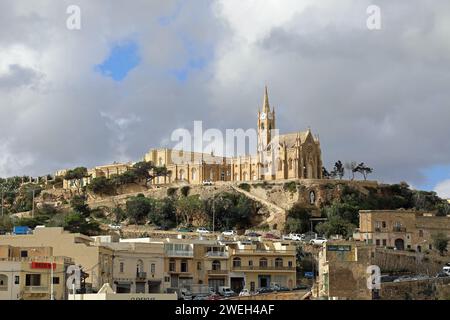 Village de pêcheurs og Mgarr avec l'église de Sainte mère Lurdskaya sur la ligne d'horizon Banque D'Images