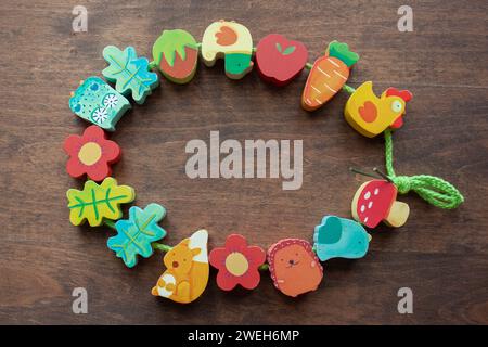 Minsk, Biélorussie - 05 juillet 2014 : perles en bois de Djeco enfilées sur de la dentelle sur la table, mise au point sélective. Jouets éducatifs Banque D'Images