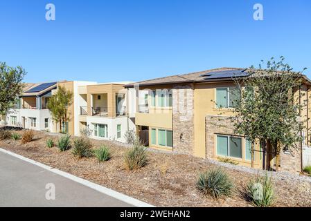 Rangée de nouvelles maisons jumelées économes en énergie avec des panneaux solaires sur le toit dans un développement de logements par un jour clair d'automne Banque D'Images