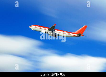 un avion de passagers rouge et blanc peu après le décollage, arrière-plan flou Banque D'Images