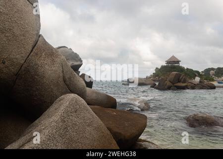 Rochers de rivage au milieu de la mer des caraïbes avec point de vue de cabane à la plage de cabo san juan dans le parc tayrona Banque D'Images