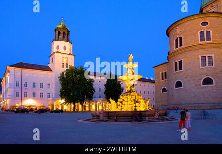 Résidence place dans la lumière du soir, heure bleue, avec fontaine lumineuse et deux touristes, Salzbourg, Tyrol, Autriche Banque D'Images