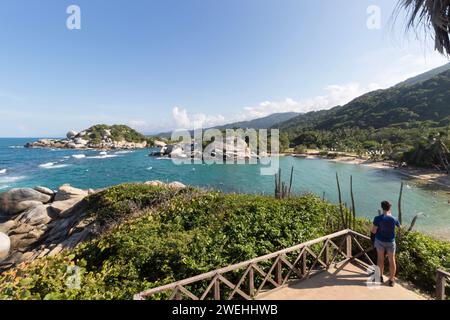 Jeune homme appréciant le paysage de plage de cabo san juan d'un point de vue avec des montagnes rocheuses et la mer turquoise des caraïbes en arrière-plan Banque D'Images