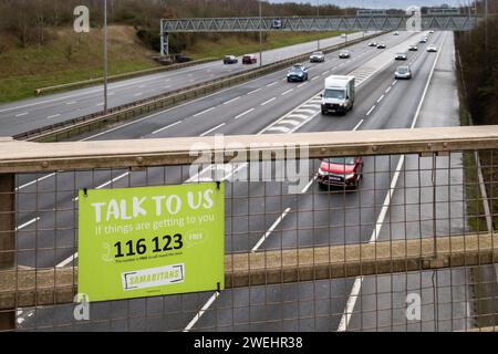 Le panneau « Talk to US » de l'association caritative samaritaine « Talk to US » se trouve sur un pont sur l'autoroute M6, près de Birmingham, au Royaume-Uni. Banque D'Images