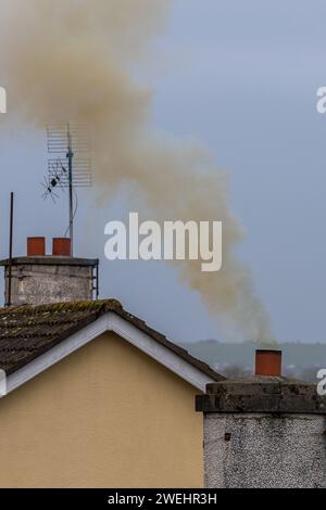 Fumée s'élevant d'une cheminée de maison en Irlande Banque D'Images