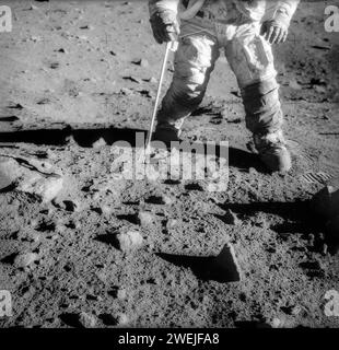 L'astronaute américain Charles Conrad Jr., commandant de la mission d'atterrissage lunaire Apollo 12, pendant une activité extravéhiculaire sur la surface lunaire, la liste de contrôle EVA est sur le poignet gauche de Conrad, une pince, un Apollo Lunar Hand Tool, est tenu dans sa main droite, NASA, 20 novembre 1969 Banque D'Images