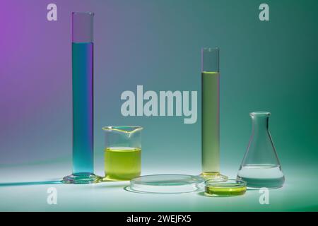 Fond abstrait avec concept de laboratoire - verrerie de laboratoire contenant du liquide de couleur et podium transparent rond pour la présentation du produit cosmétique sur Banque D'Images