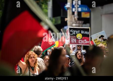 26 janvier 2024, Melbourne, Australie. Un manifestant tient une pancarte indiquant « Stop Black Deaths in Custody » alors qu'ils marchent avec environ 30 000 autres manifestants qui se rassemblaient contre Australia Day, ou invasion Day. Crédit : Jay Kogler/Alamy Live News Banque D'Images