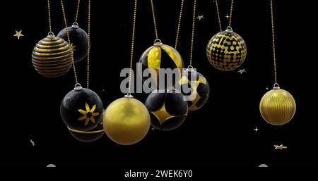 Boules de noël noires et dorées balançant avec des étoiles dorées sur fond noir Banque D'Images