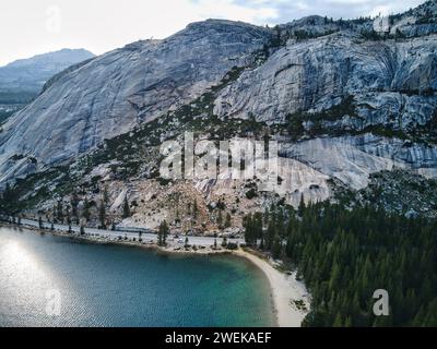 Un lac serein niché au milieu d'arbres luxuriants, avec des montagnes majestueuses en toile de fond Banque D'Images