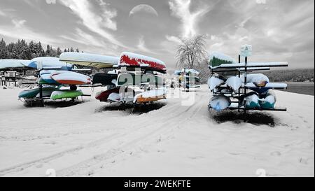 Un paysage enneigé avec une ligne de canoës près du bord de l'eau Banque D'Images