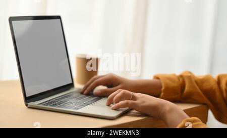Photo recadrée de la jeune femme freelance travaillant avec la tablette numérique sur le bureau à la maison Banque D'Images