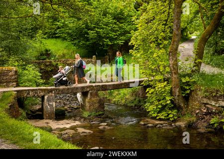 Royaume-Uni, Angleterre, Lancashire, Colne, Wycoller, famille traversant Clam Bridge, clapperbridge de dalle de pierre historique Banque D'Images