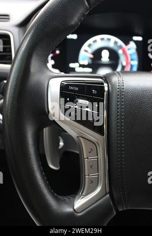 Boutons et panneau de commande électronique sur Un volant et tableau de bord numérique floue à l'intérieur de la voiture moderne Banque D'Images