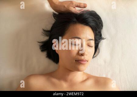 Vue d'en haut femme sereine recevant un massage de la tête dans le spa Banque D'Images