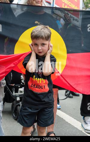 Melbourne, Australie. 26 janvier 2024. Le jeune Cody se couvre les oreilles lors de la manifestation annuelle du jour de l'invasion. La manifestation annuelle de la Journée de l'invasion à Melbourne a été organisée par les Australiens autochtones et leurs alliés, appelant à la fin de la célébration de la Journée de l'Australie et à la reconnaissance de la souveraineté autochtone à Melbourne en Australie. Crédit : SOPA Images Limited/Alamy Live News Banque D'Images