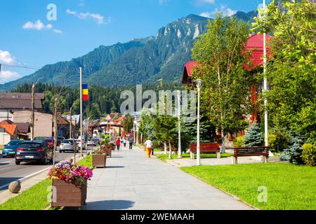 La rue principale Bulevardul Libertății avec des stands de vendeurs et vue sur les montagnes Bucegi, Busteni, Roumanie Banque D'Images