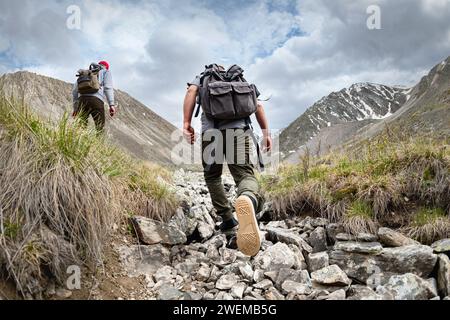 Deux jeunes touristes randonneurs actifs avec des sacs à dos promenades dans les montagnes Banque D'Images