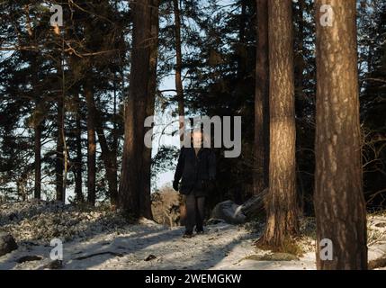 homme retraité marchant à travers la forêt dans la neige Banque D'Images