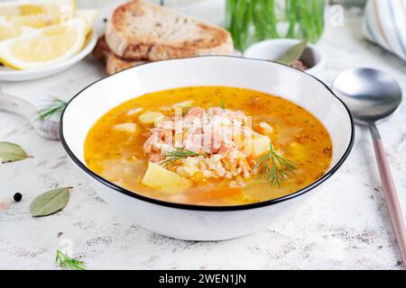 Soupe de poisson avec saumon, légumes et riz dans un bol blanc. Soupe de saumon. Banque D'Images