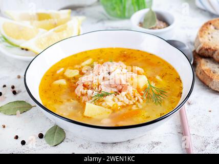 Soupe de poisson avec saumon, légumes et riz dans un bol blanc. Soupe de saumon. Banque D'Images