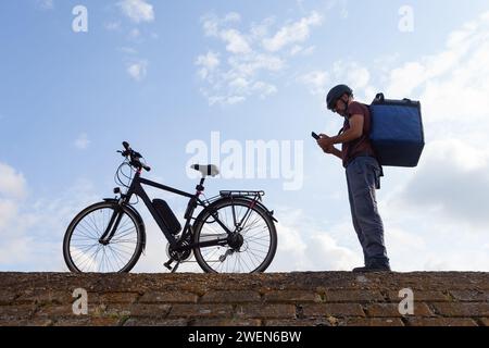 livreur de vélo prenant commande sur l'application de téléphone Banque D'Images