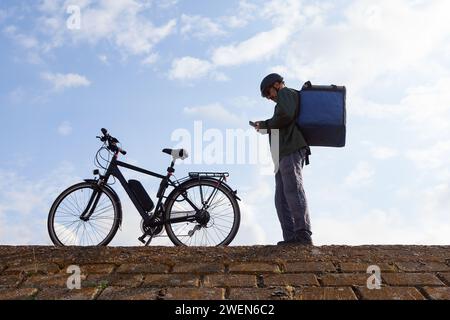 livreur de vélos prenant commande par téléphone Banque D'Images
