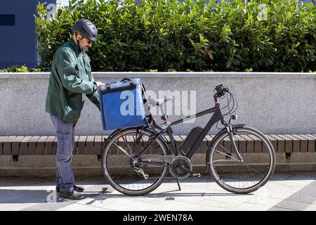 livreur de vélo électrique préparant la commande pour la livraison Banque D'Images