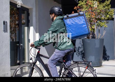livreur sur vélo électrique arrivant à destination Banque D'Images