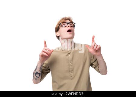 inspiré par l'idée d'un jeune homme aux cheveux rouges dans une chemise beige porte des lunettes pour la vision sur un fond blanc Banque D'Images