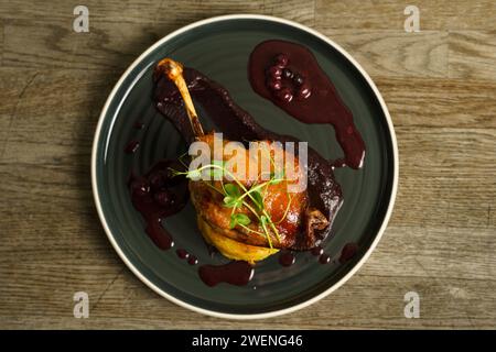 Cuisse de canard rôtie sur purée de pommes de terre avec oignon, crème de chou violet et jus de myrtille Banque D'Images