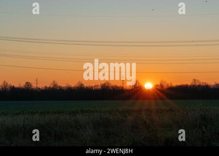 Sonnenaufgang über Feld mit Strommast Banque D'Images