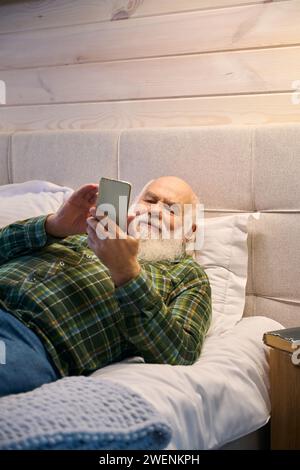 Retraité est fatigué et se couche pour se reposer sur un lit confortable Banque D'Images