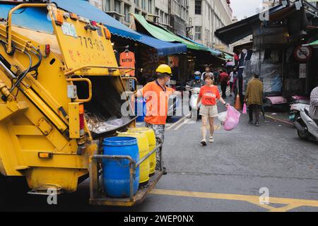 Yilan, République de Chine - 2 octobre 2023 : un camion à ordures et des binmen dans les rues de Yilan, Taïwan, assurent l'enlèvement des déchets. Banque D'Images