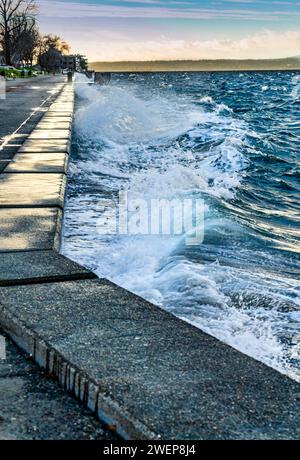 Les vagues s'écrasent sur la digue de la mer à Alki Beach à West Seattle, Washington. Banque D'Images