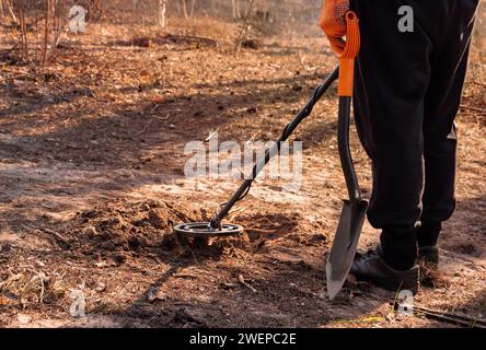 Homme avec un détecteur de métaux et une pelle est à la recherche d'un Trésor dans la forêt. Banque D'Images