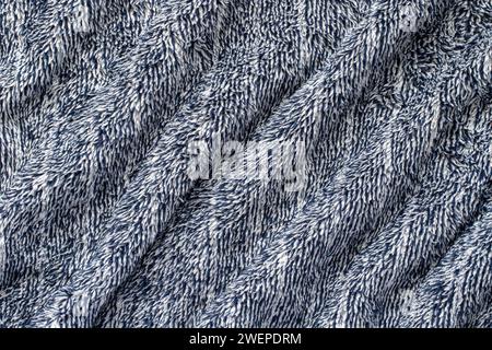Tissu doux bleu foncé de plaid en peluche confortable. Fond de couverture chaud ondulé. Banque D'Images