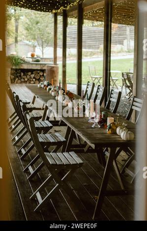 Rangées de tables en bois avec des chaises disposées soigneusement sur une terrasse dans une configuration de banquet d'automne Banque D'Images