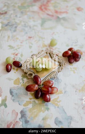 Quelques boucles d'oreilles de mariage entourées de raisins dans un plateau Banque D'Images