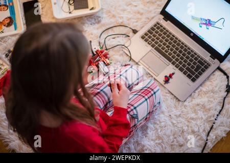 Tallinn, Estonie - 25 décembre 2023 : enfant construisant un robot Lego Education WEDO en mouvement à la maison. Banque D'Images