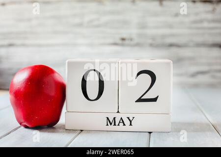 Blocs de calendrier en bois blanc avec la date du 2 mai et une pomme rouge pour la Journée nationale d'appréciation des enseignants. Banque D'Images