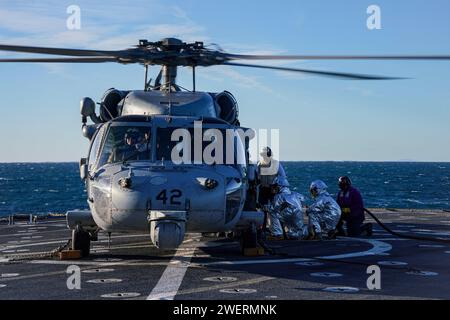 Les marins ravitaillent en carburant un SH-60S Seahawk, affecté à l'hélicoptère Sea combat Squadron (HSC) 23, sur le pont d'envol à bord du navire amphibie USS Harpers Ferry (LSD 49), alors qu'il se dirigeait dans l'océan Pacifique, le 7 janvier 2024. Le Boxer Amphibious Ready Group, composé de l'USS Boxer (LHD 4), de l'USS Somerset (LPD 25) et de Harpers Ferry, et de la 15e Marine Expeditionary Unit embarquée, mènent des opérations de routine et d'entraînement intégrées dans la 3e flotte américaine. (Photo de l'US Navy par le spécialiste des communications de masse de 2e classe sang Kim) Banque D'Images