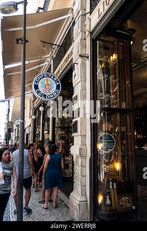 Panneau rond suspendu à l'entrée du café Confeitaria Colombo situé à Goncalves Dias rue dans le quartier Centro tandis que les piétons passent. Banque D'Images