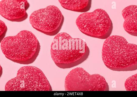 Bonbons de gelée sucrés en forme de coeurs sur fond rose, gros plan. Fête de la Saint-Valentin Banque D'Images