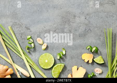 Style minimal avec des tranches de citron, de la citronnelle fraîche et du gingembre sur fond gris. Espace pour le texte et le design. Ce sont des herbes saines et des épices dans cooki Banque D'Images