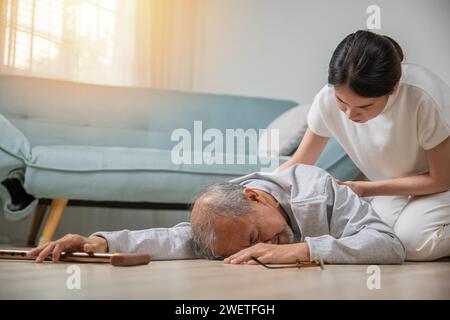 vieil homme avec bâton de marche tomber sur le sol et camp de petite-fille pour aider à soutenir Banque D'Images