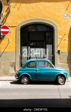 Bleu Fiat 500 garé devant un ancien palais à la façade jaune, dans le quartier Oltrarno de Florence, Toscane, Italie Banque D'Images