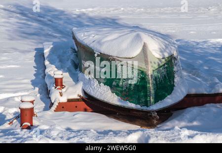 Bateau couvert de neige sur la jetée..bateau inversé sous la neige..bateau sous la neige sur la jetée.. Banque D'Images