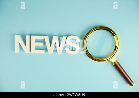 Nouvelles lettres de l'alphabet avec loupe sur fond bleu Banque D'Images