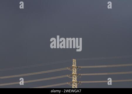 Image abstraite d'un pylône électrique et de fils haute tension contre un ciel couvant. Kanagawa, Japon. Banque D'Images